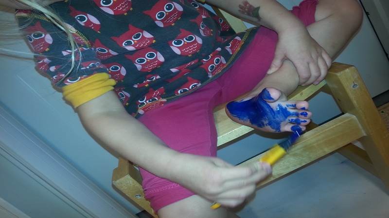 Pojke målar sin fot.